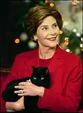 Laura Bush holding family cat India, a solid-black American Shorthair (2004)