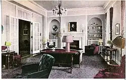 Formal sitting room with couches, chairs, fireplaces, and built-in shelves