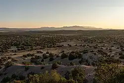 the Ortiz Mountains, Sandia Mountains, and Manzano Mountains are visible in the background.