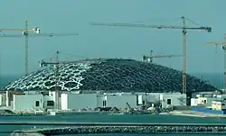 Louvre Abu Dhabi under construction in 2015, its dome built up of layers of stars made of octagons, triangles, and squares