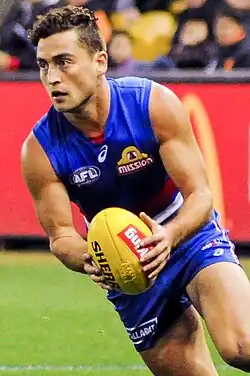 Male athlete running whilst holding football