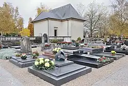 Building where ceremonies take place. Foreground: the grave of Lucien Wercollier.