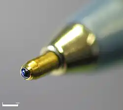 Close-up picture of the tip of a ballpoint pen showing the ink-covered ball.