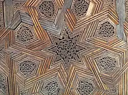 Carved geometric and arabesque details in the cedar wood doors of the lateral chambers off the courtyard