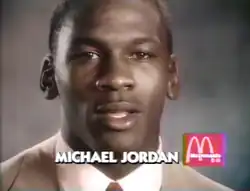 Michael Jordan in tan suit against a gray background. At the foreground is text saying "Michael Jordan" and the McDonald's logo.