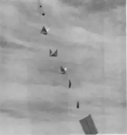 A vintage military photo shows a string of balloons and reflectors stretching into the sky.