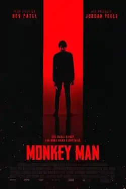 A man wielding a knife stands in front of a red opening within a plain black space.