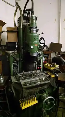 A manual grinding machine with a crank controlled X-Y table.
