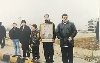 Mourners on Zahran street hold up portrait of King Hussein