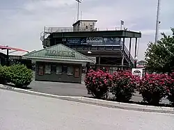 Entrance showing ticket booth and press box at top of grandstand