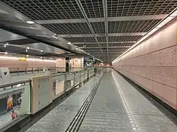 A corridor which the Art-in-Transit artwork is located along. There is also a view of the station platform on the bottom left corner.