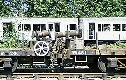 A pair of 4xx-series 'RW' bolster wagons at Neasden, with some derelict A Stock behind.