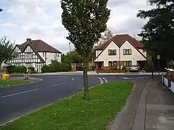 A row of suburban houses with white gabled ends and black timber beams