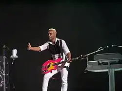 A color photograph of British-American bassist Tony Kanal performing live in 2009.