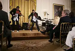 President George W. Bush and guests watch violinists Tourie and Damien Escobar, as they perform Friday, June 22, 2007 in the East Room of the White House, in celebration of Black Music Month.