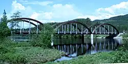 A bridge with three wooden arches, spanning a river