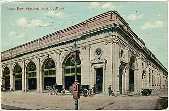 A postcard of a large railway station facade