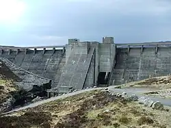 A large concrete dam in an upland moorland