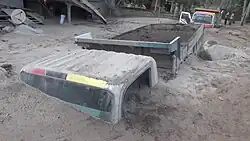 A truck partially submerged in lahar.