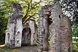 A colour photograph of a ruined building with no roof, constructed of stone and red brick