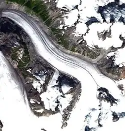 Satellite imagery of a glacier in a valley surrounded by rock and ice