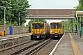 Merseyrail Class 508s pass at the station.