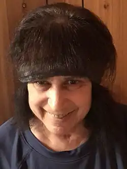 Photo of a woman with dark, voluminous hair