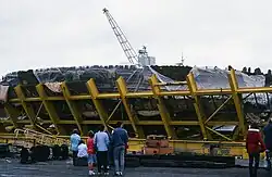 People standing in front of the wreck of the Mary Rose while in its protective cage