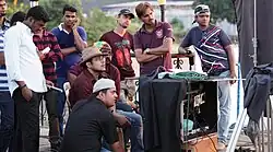 A group of men, including filmmaker Pritish Chakraborty sit around a camera