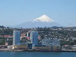 View of Puerto Montt's sea-side downtown in foreground and Osorno volcano in the background.