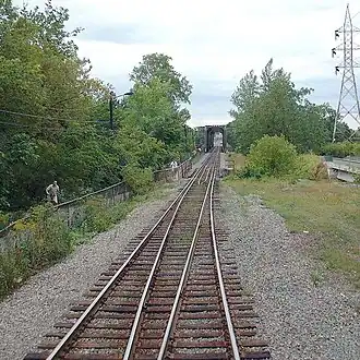 CPR's Bordeaux Railway Bridge gauntlet track in Montreal, Quebec. The bridge is visible in the background. The bicycle trail (shared-use path) is visible to the left and the unnamed bridge to Perry Island[4][5] is visible to the right.