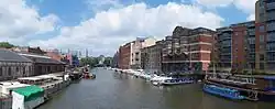 The view north from Redcliffe Bridge, showing one yellow water taxi, warehouses and various buildings along Welsh Back