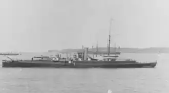Black and white photograph of a ship at sea with two ships in the background