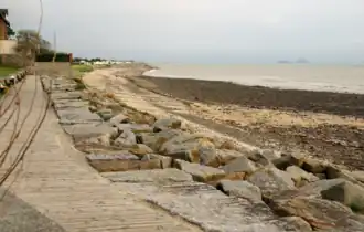 The coast of Saint-Jean-le-Thomas with views of Mont Saint-Michel and the rock of Tombelaine in the evening mist