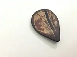 A traditional hand crafted coconut shell plectrum, used for playing the sarod. Also known as a "Javva".