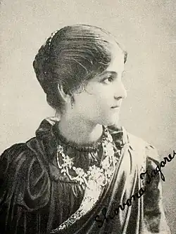 Young woman looking to the right, wearing a high-necked dark dress, a gemstone necklace, and a light-colored sash. Her name, Shovona Tagore, is signed in the lower right.