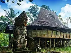 A traditional Nias house and megalithic statue in Sisarahili
