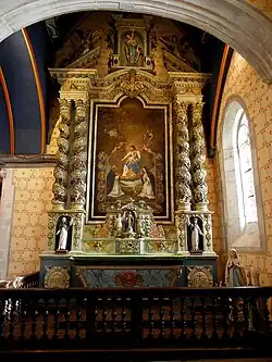 The "rosary" altarpiece. The altar of the Holy Rosary has two twisted columns that frame a painting of the death of a dedicated Christian in the presence of Dom Michel le Nobletz, a famous Breton missionary from the 17th century. The altar has statues of Saint Peter and Saint Paul on either side as well as a statue of Saint Joseph at the top.