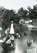 Standing on the edge of pond, circa 1910.