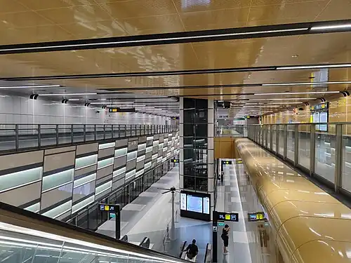 A view of the station platform from the concourse, with a lift shaft in the middle.