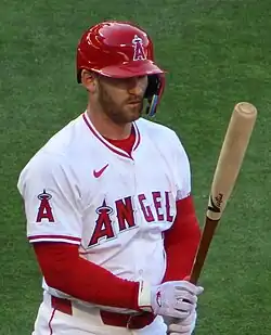 Ward standing on the infield grass and holding his bat vertically in front of him.