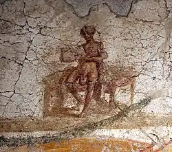 A nude male with an enlarged scrotum holding a scroll. Wall painting. Suburban baths, Pompeii. 62 to 79 CE