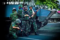 RTA troops take cover next to a Type 85 AFV near the Red Shirt barricade at Chulalongkorn Hospital