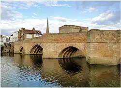 Photo of medieval stone arch bridge over river