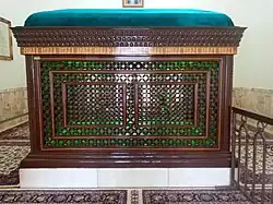 A wooden zarih encloses the grave underneath the dome