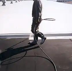 Top coating a commercial flat roof