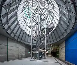 View upwards into a glazed cone from an underground station island platform