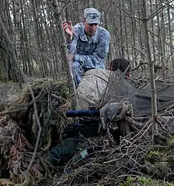 A Special Forces Master Sergeant gives pointers to two other Special Forces soldiers at a NATO sniper course in Germany.