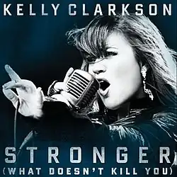 A blue-tint-in-a-black-and-white image of a woman singing. Her right hand is holding a vintage carbon microphone in front of her mouth. The microphone's wire is resting on her left hand between her thumb and her index finger. Below her, the words "Stronger" and "(What Doesn't Kill You)" are written in white upper-case letters.