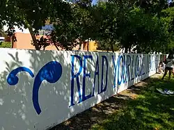 The logo of The Student Life and a "read your local newspaper" message, painted in blue against a white background on Walker Wall